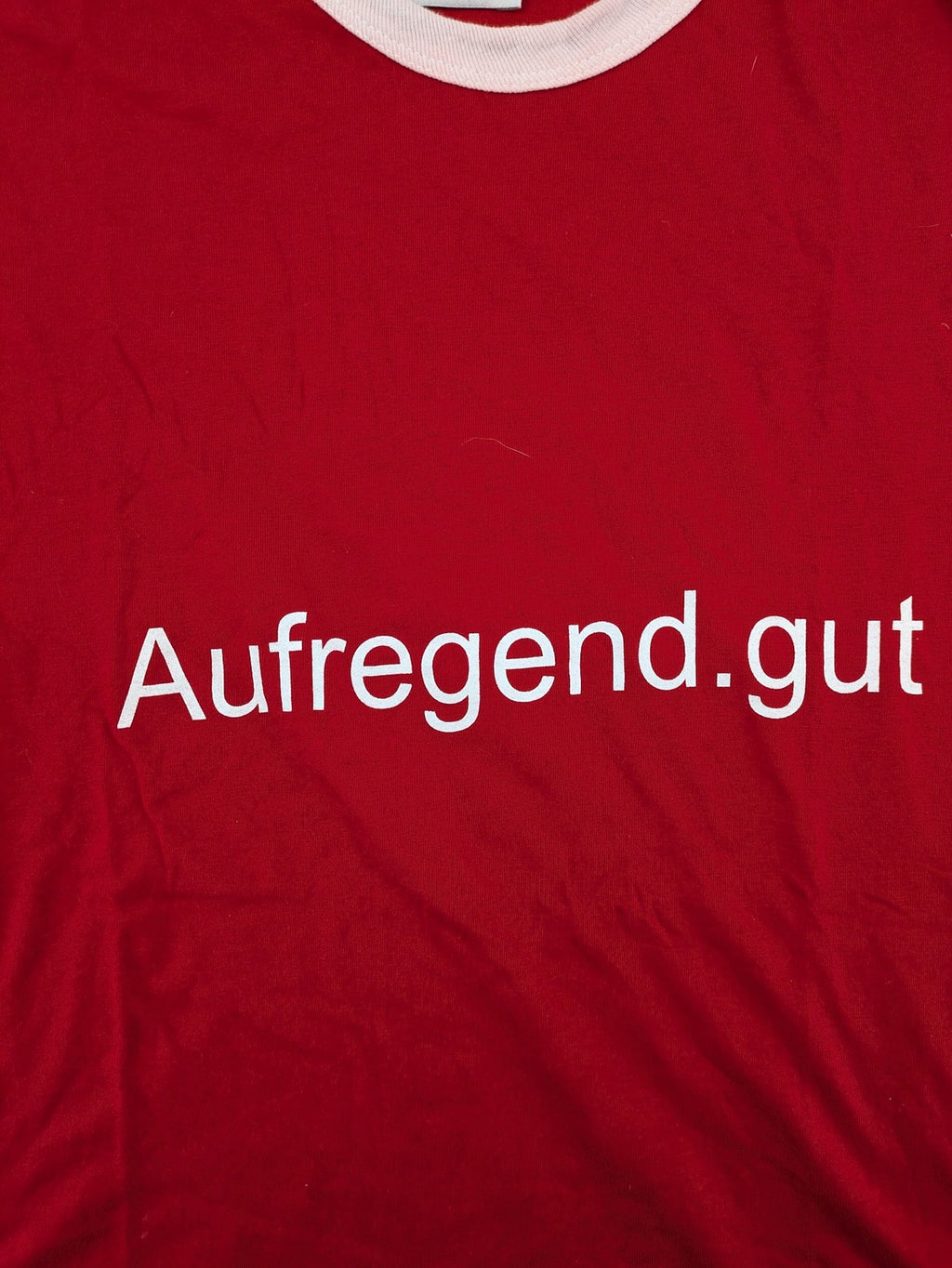 ck red t-shirt with white collar, "Aufregend.gut" print, classic ring style, cotton.