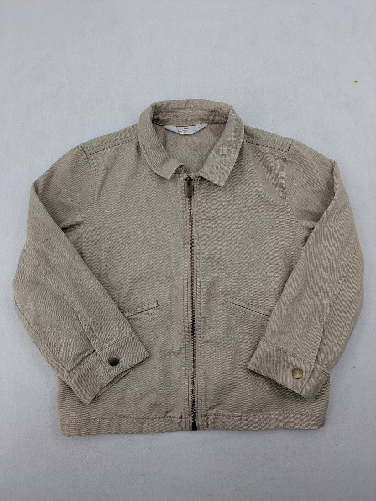 H&M beige twill coat with full zip, classic collar, and practical pockets.
