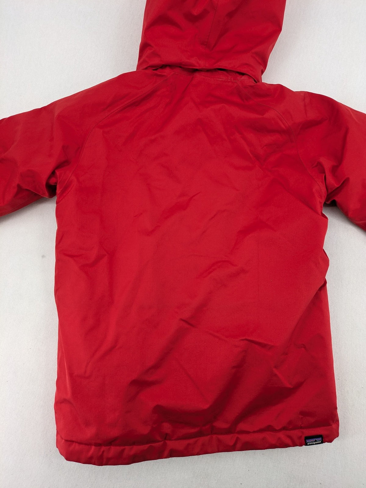 Patagonia red winter coat with hood, zip closure, snow skirt, and ski pass pocket.