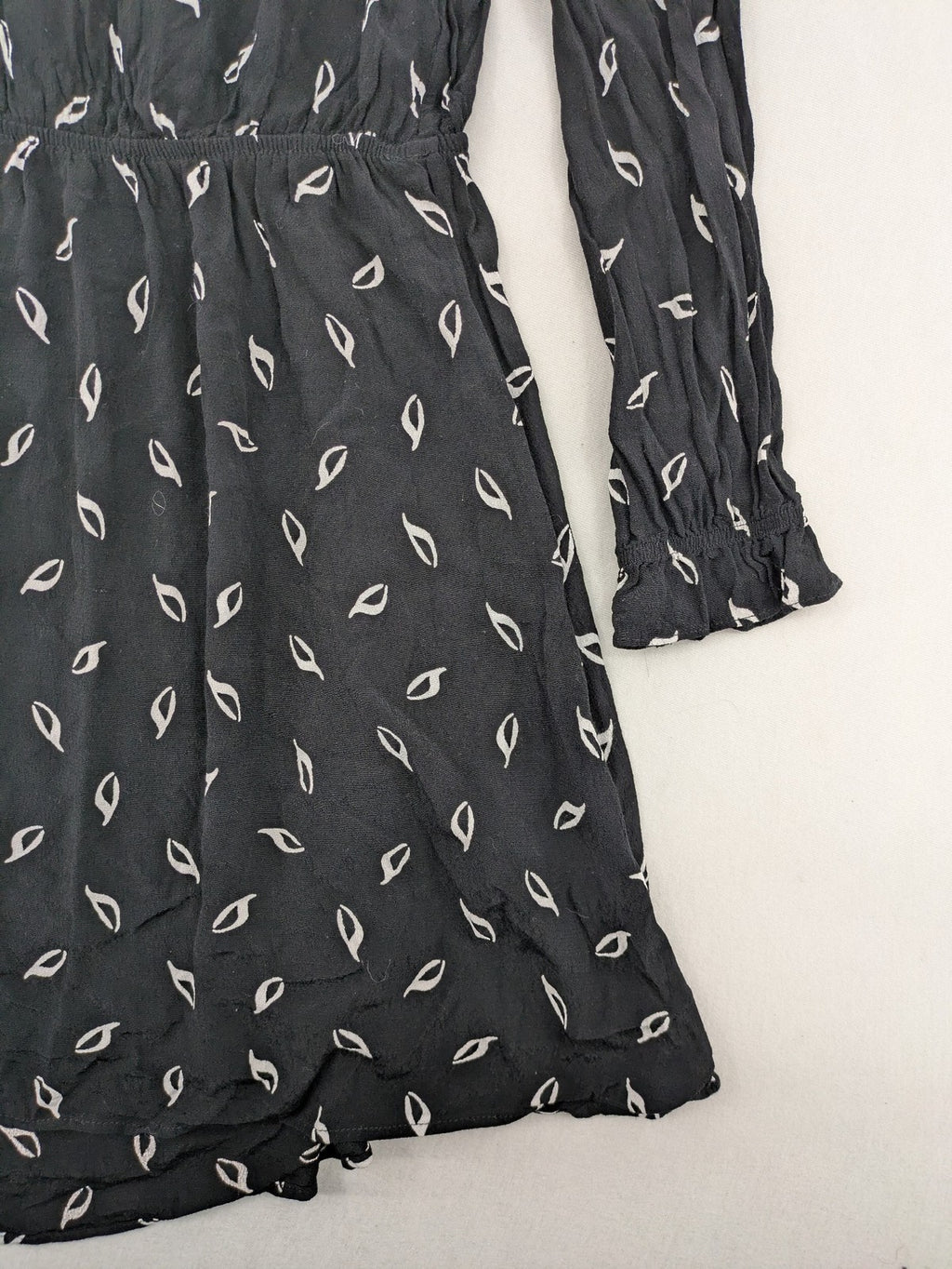 H&M grey and white dress with leaf print, V-neck, long sleeves, elastic cuffs.