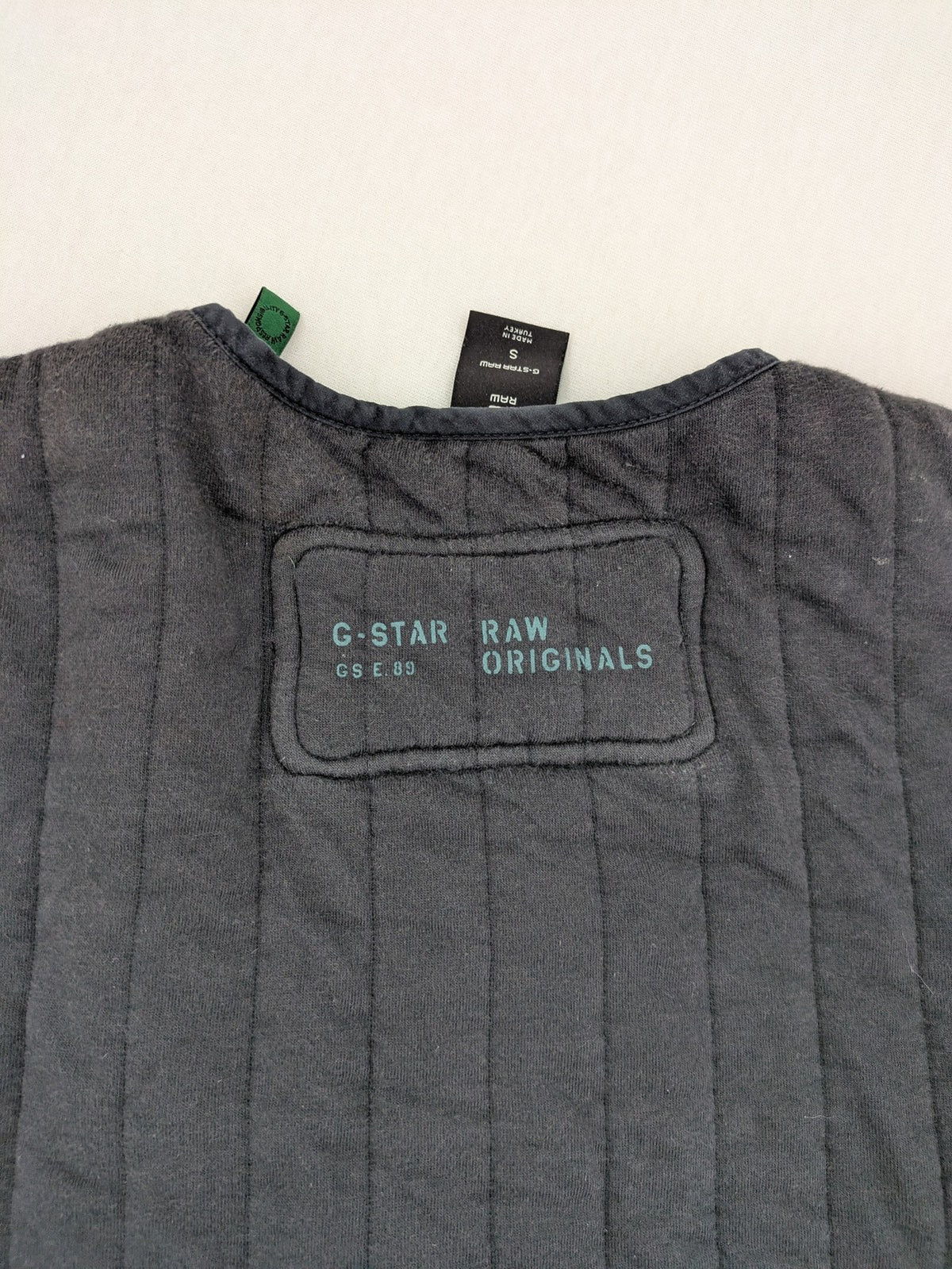 G-Star Raw grey quilted jacket with button closure and adjustable drawstring hem.