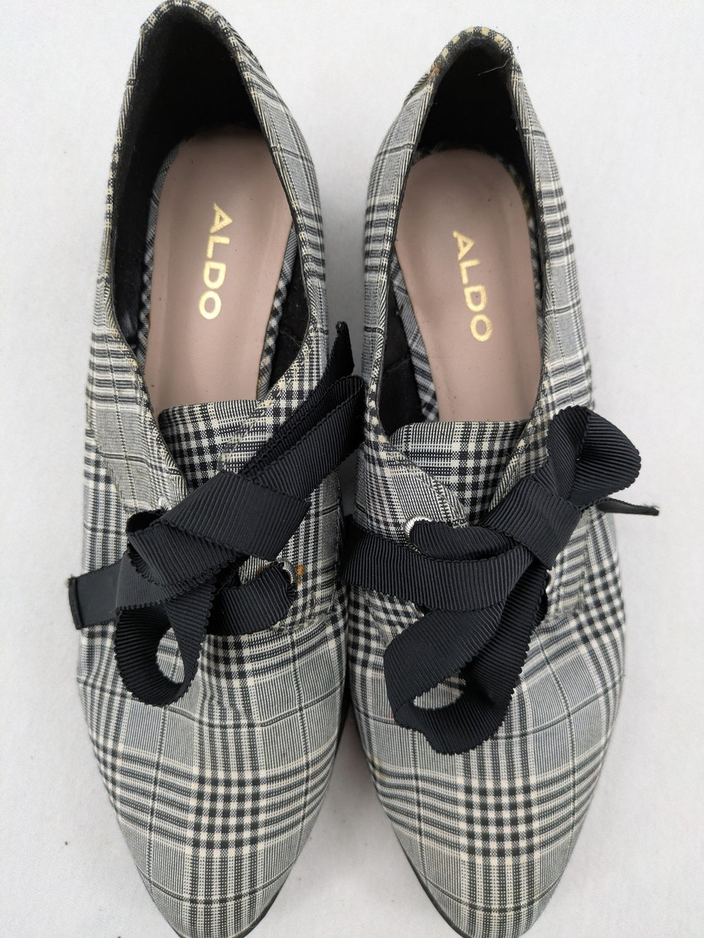 ALDO black and white checkered loafers with decorative bow detail and pointed toe.