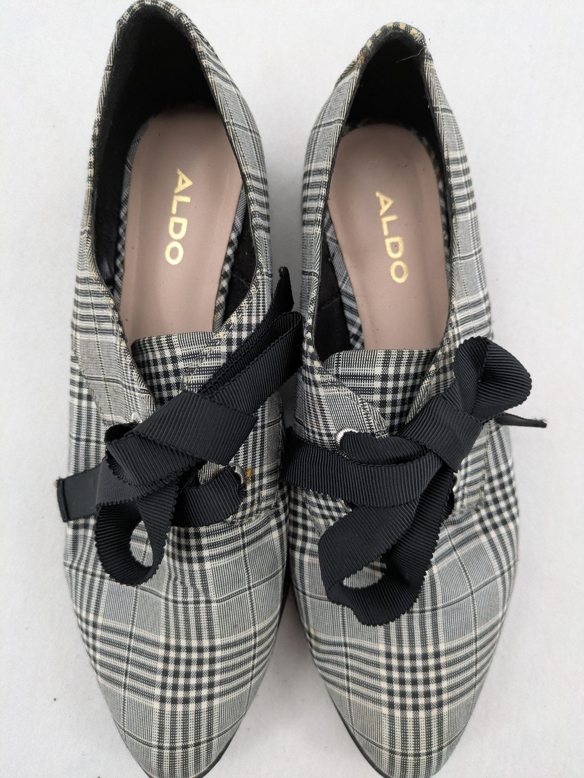 ALDO black and white checkered loafers with decorative bow detail and pointed toe.