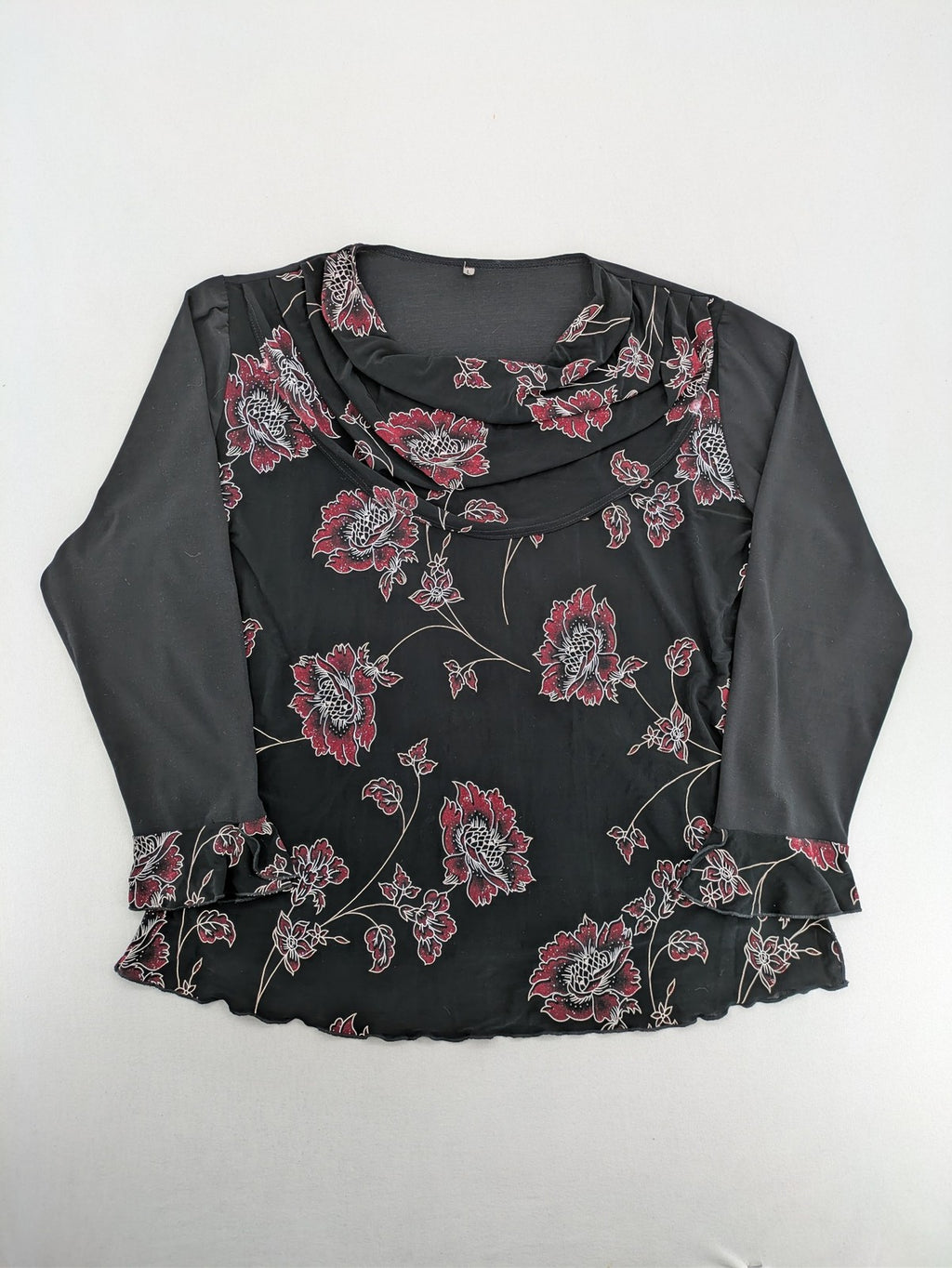 Damen black top with burgundy and white floral print, waterfall collar, and ruffled sleeves.
