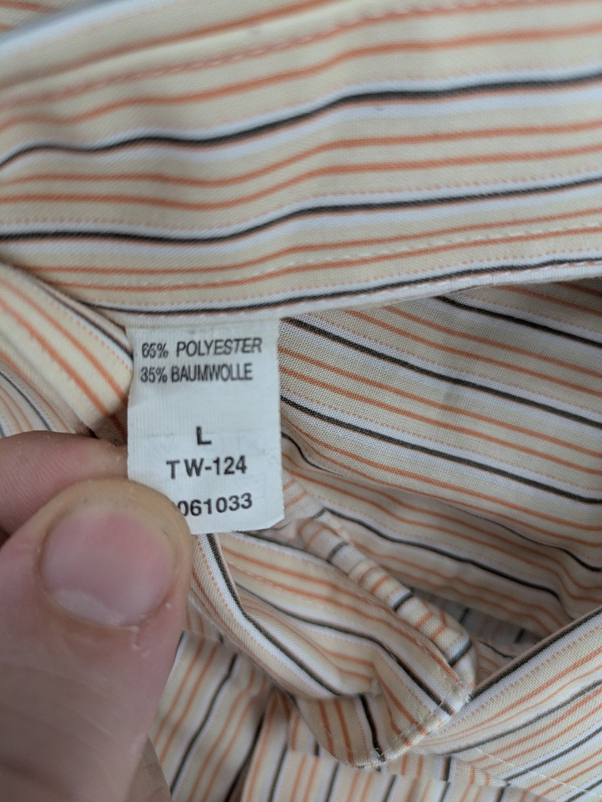Ken Baker orange short-sleeve shirt with vertical stripes and chest pocket.