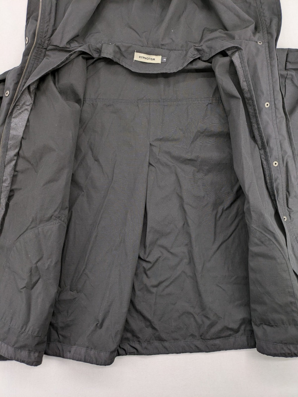 Hypnotism grey windbreaker jacket with hood, snap buttons, and zip closure.