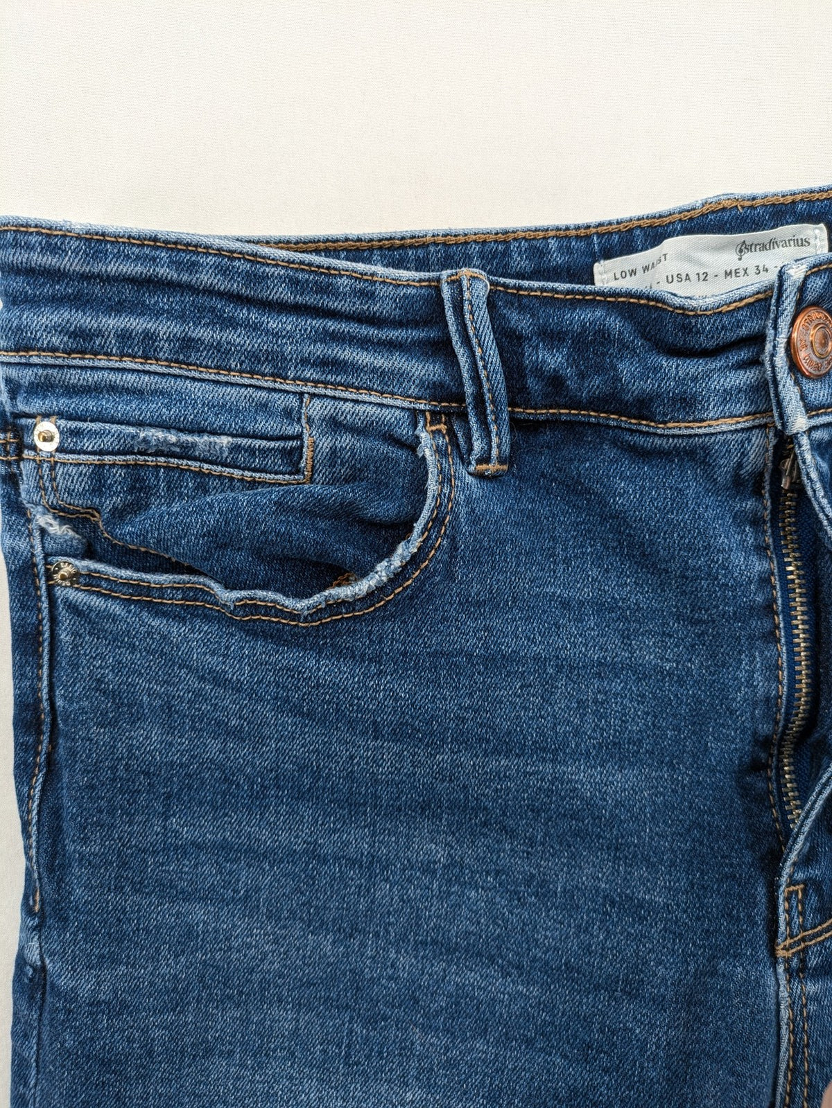 Stradivarius blue low waist skinny jeans with subtle fading and classic denim texture.