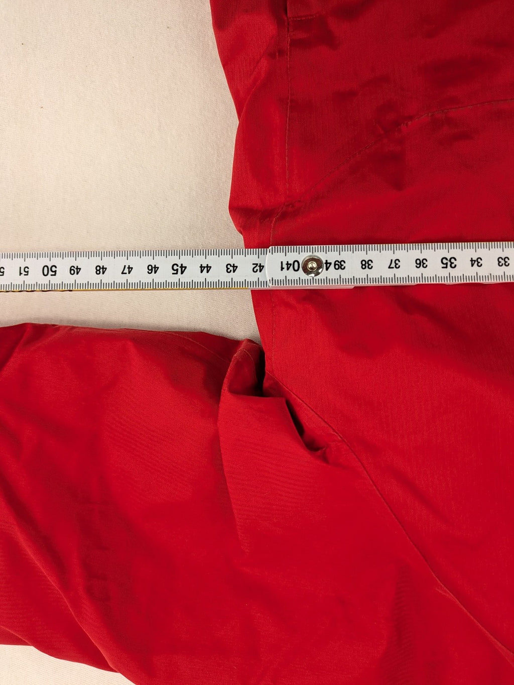 Patagonia red winter coat with hood, zip closure, snow skirt, and ski pass pocket.