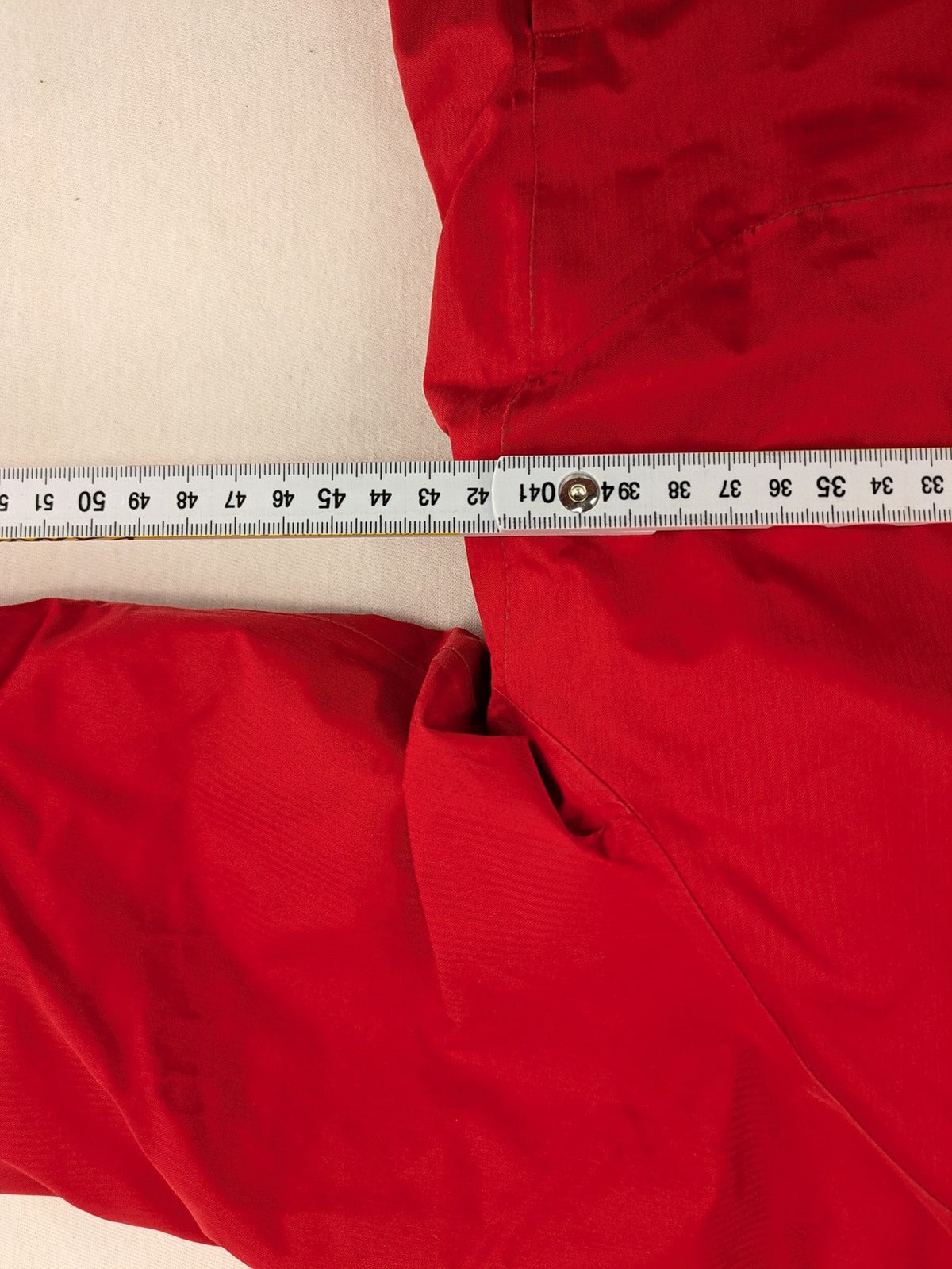 Patagonia red winter coat with hood, zip closure, snow skirt, and ski pass pocket.