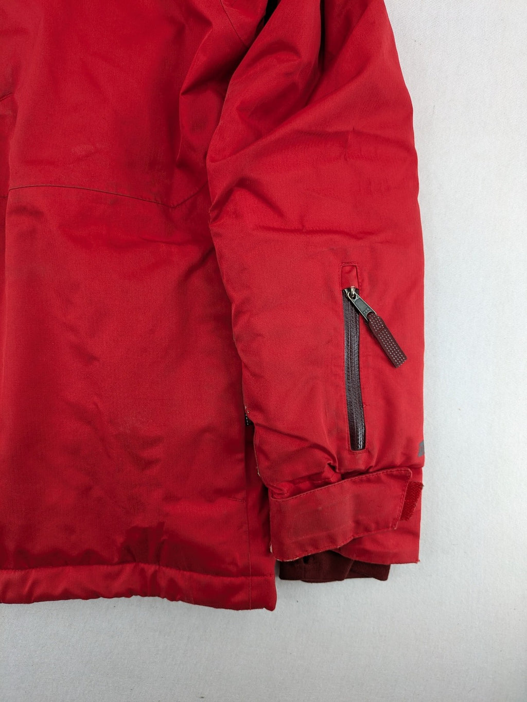 Patagonia red winter coat with hood, zip closure, snow skirt, and ski pass pocket.