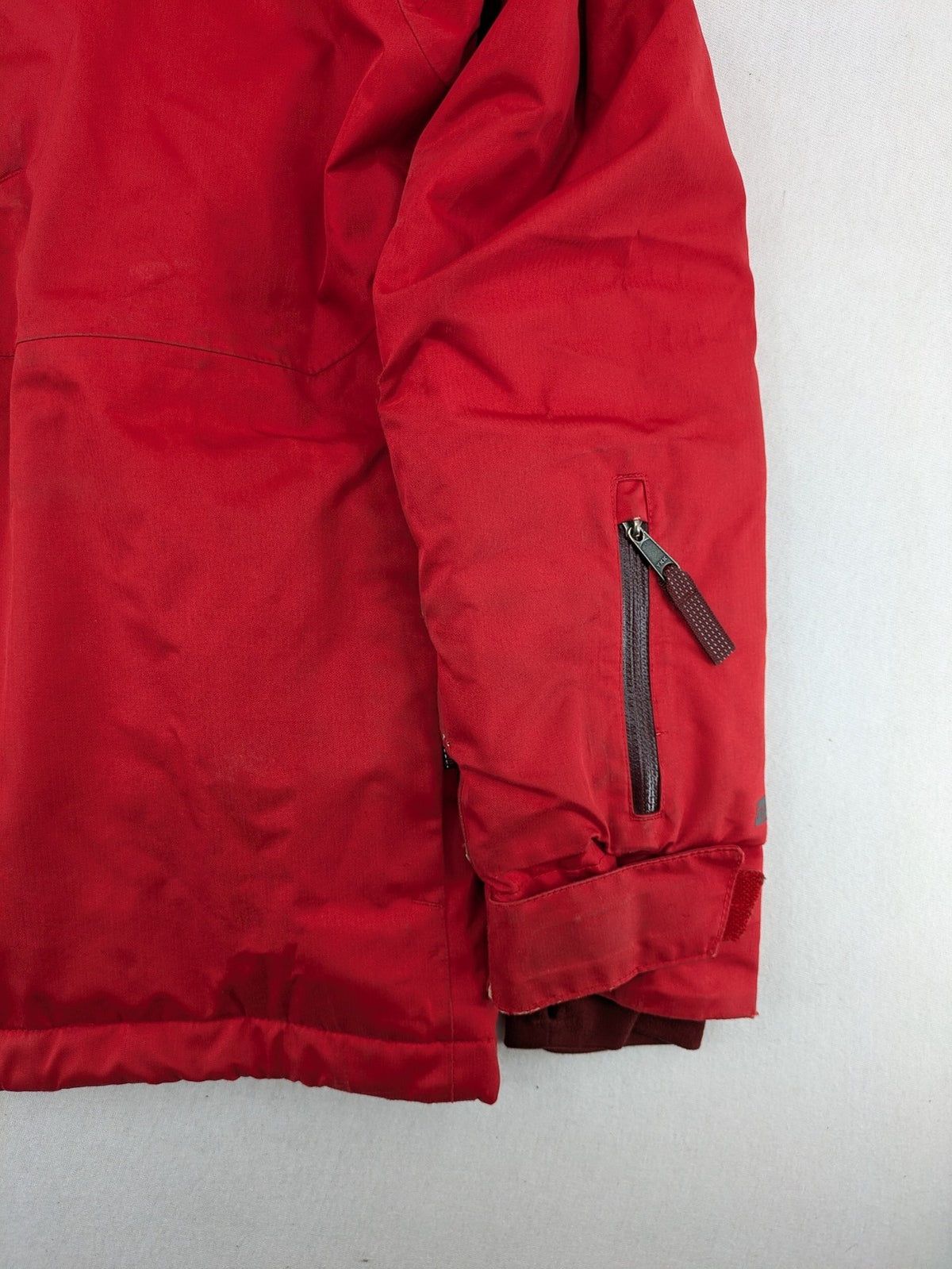 Patagonia red winter coat with hood, zip closure, snow skirt, and ski pass pocket.