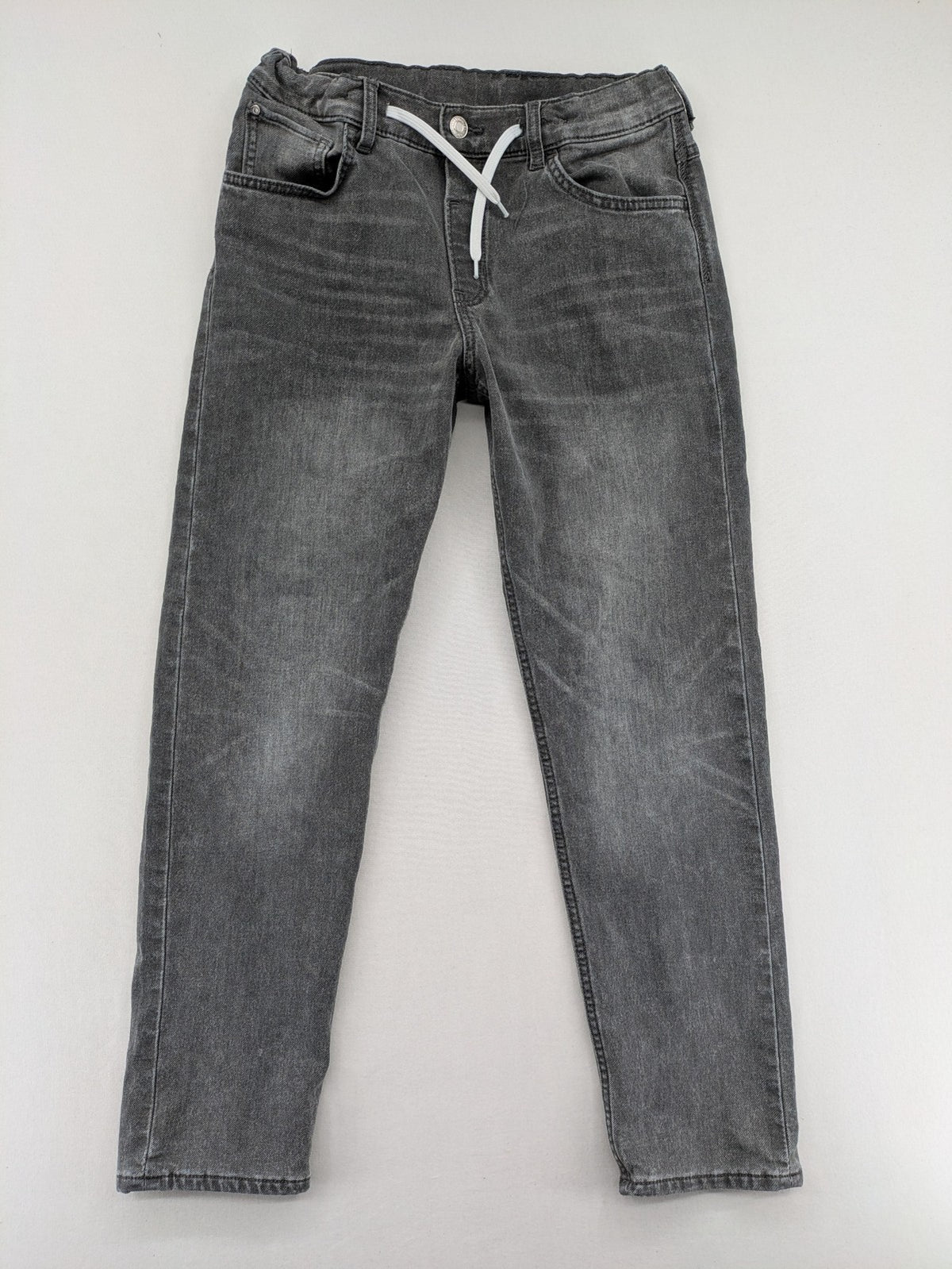 H&M grey jogger jeans with elastic waistband and drawstring, stylish washed look.
