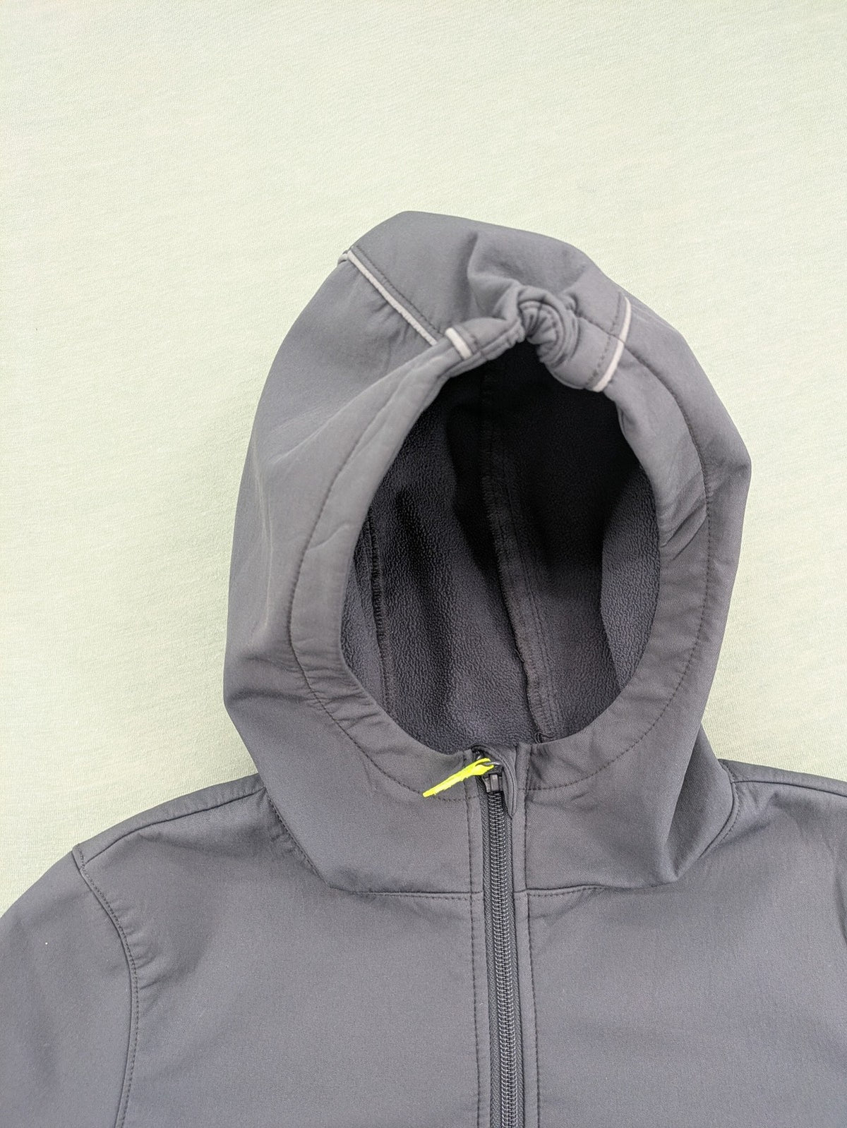 Yigga grey softshell coat with fleece lining, hood, and reflective details.