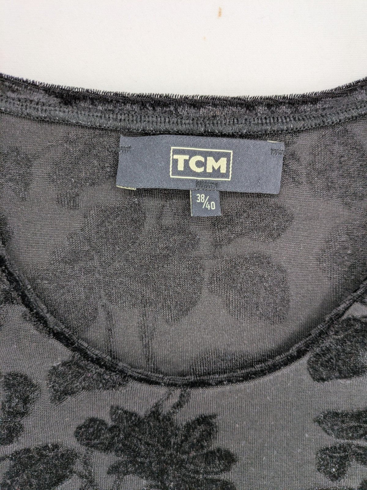 TCM black long sleeve top with floral flock print on sheer fabric.