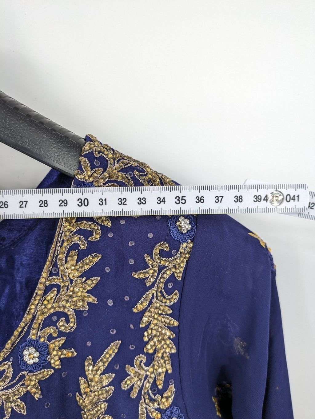 Bollywood bridal party dress gold with intricate blue embroidery and flowing Anarkali silhouette.