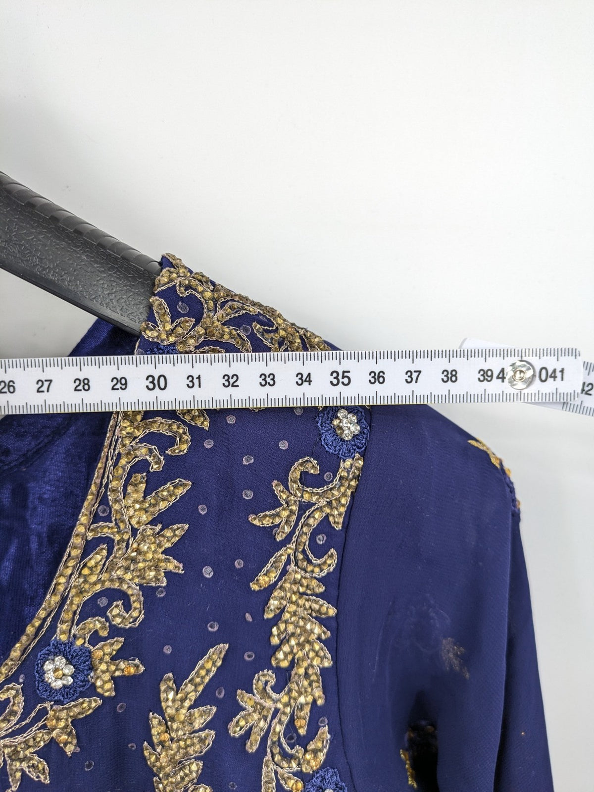 Bollywood bridal party dress gold with intricate blue embroidery and flowing Anarkali silhouette.