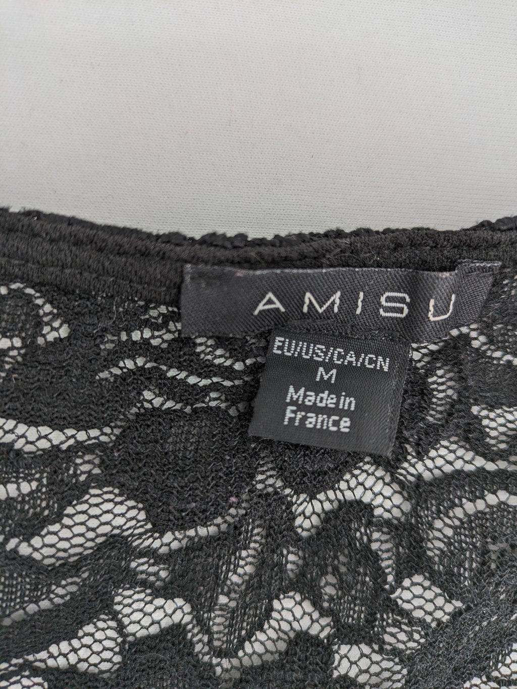 Amisu black peplum top with floral lace sleeves and delicate lace trim.