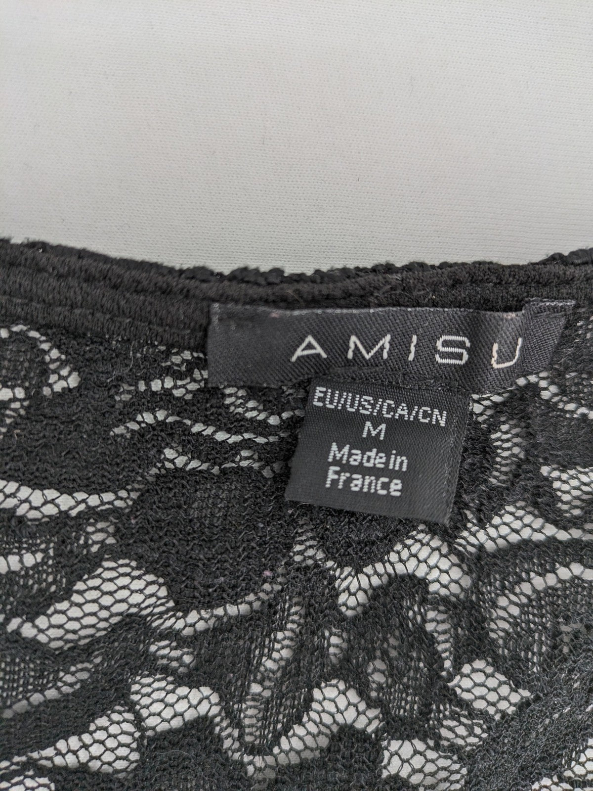 Amisu black peplum top with floral lace sleeves and delicate lace trim.