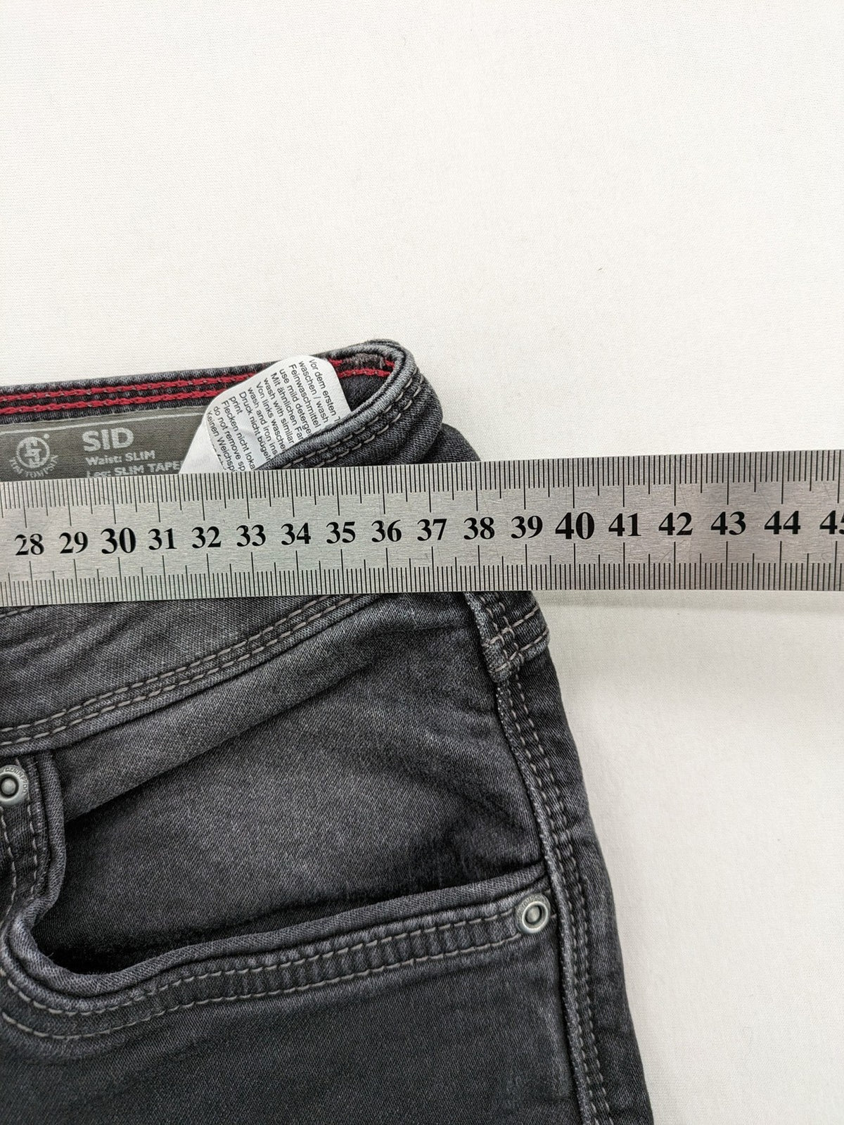 Tom Tompson grey slim tapered jeans with washed denim finish and subtle branding.