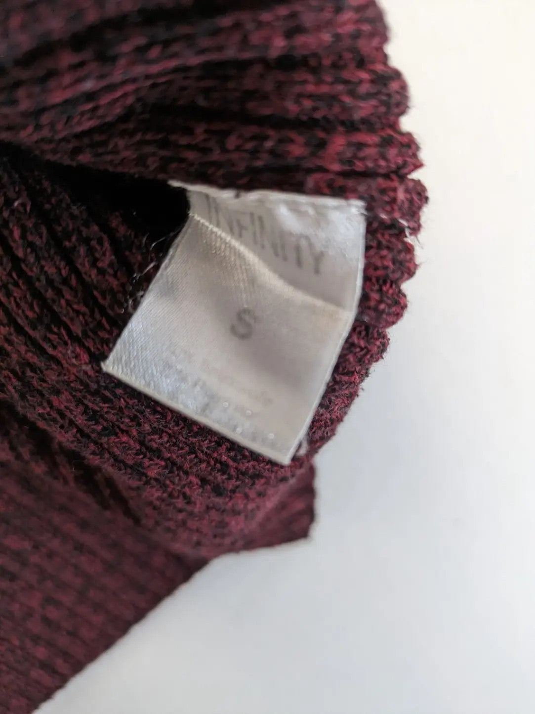 Infinity burgundy turtle neck jumper with quarter-zip and ribbed knit texture.