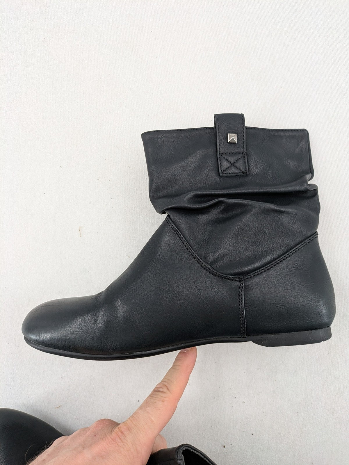 DAF black booties with decorative strap and studded details, made of faux leather.