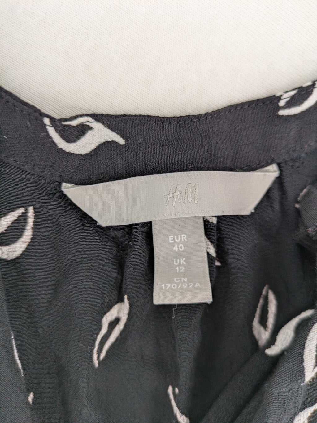 H&M grey and white dress with leaf print, V-neck, long sleeves, elastic cuffs.