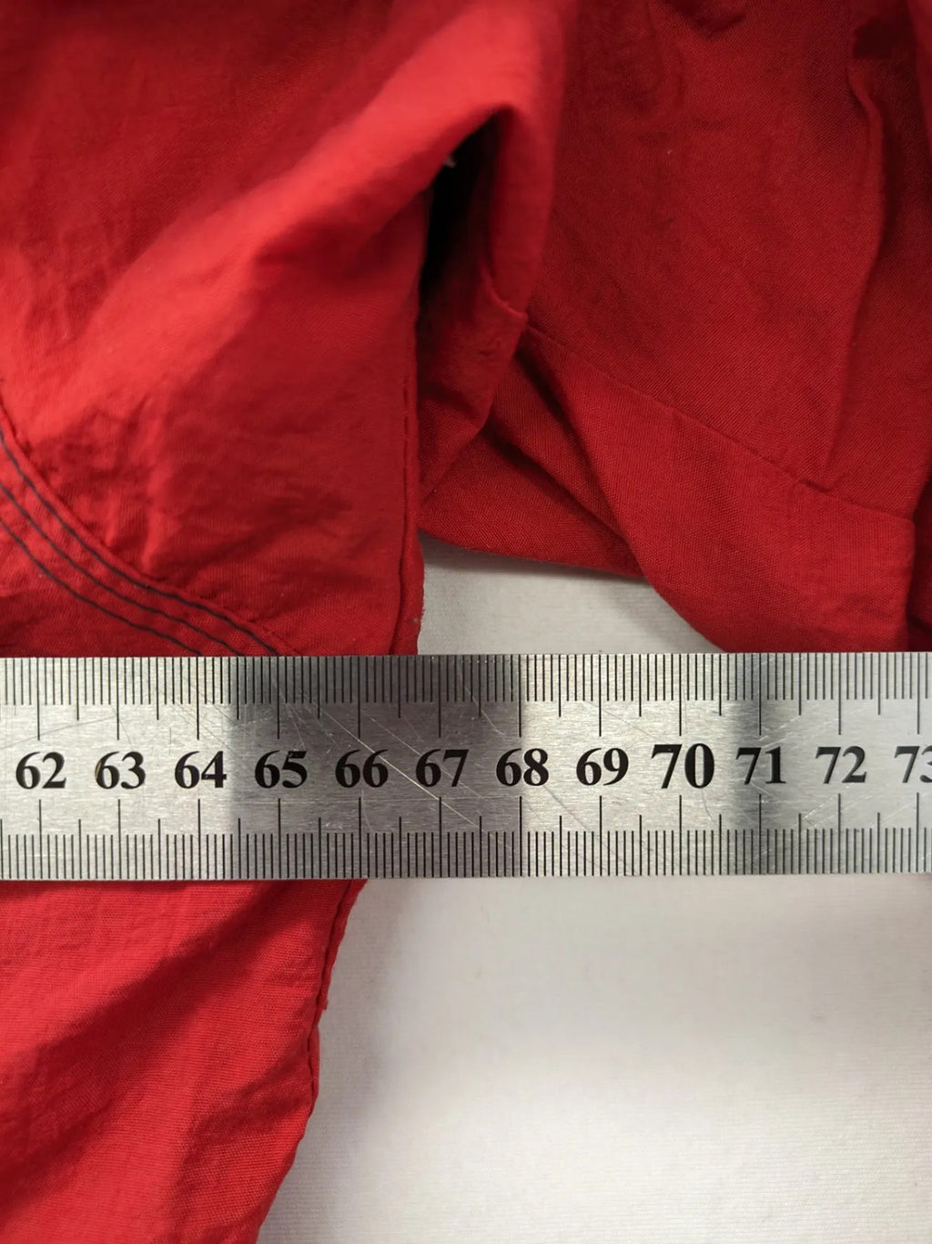 Bush Sportswear red trekking jacket with front zipper, multiple pockets, and striped lining.