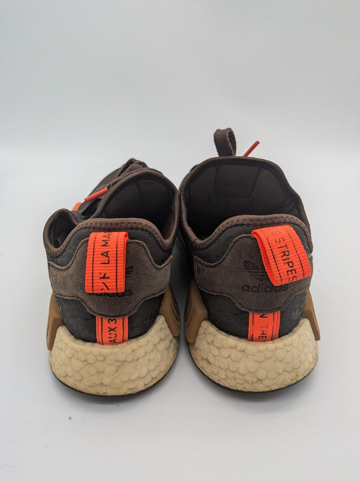 Adidas NMD R1 sneakers brown with tan stripes and bright orange accents, Boost sole.