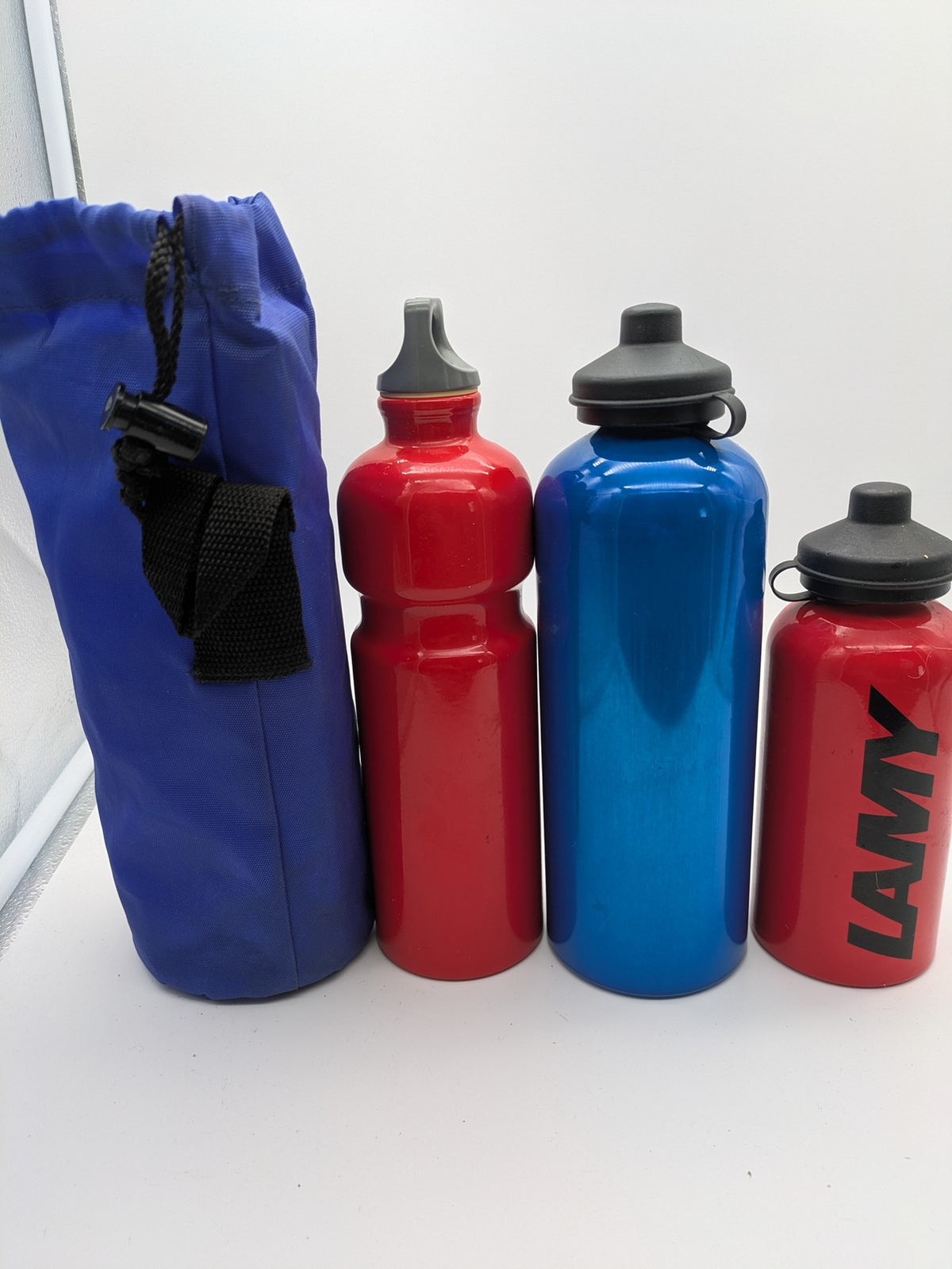 SIGG blue thermos set with red accents, durable aluminum, stylish outdoor design.