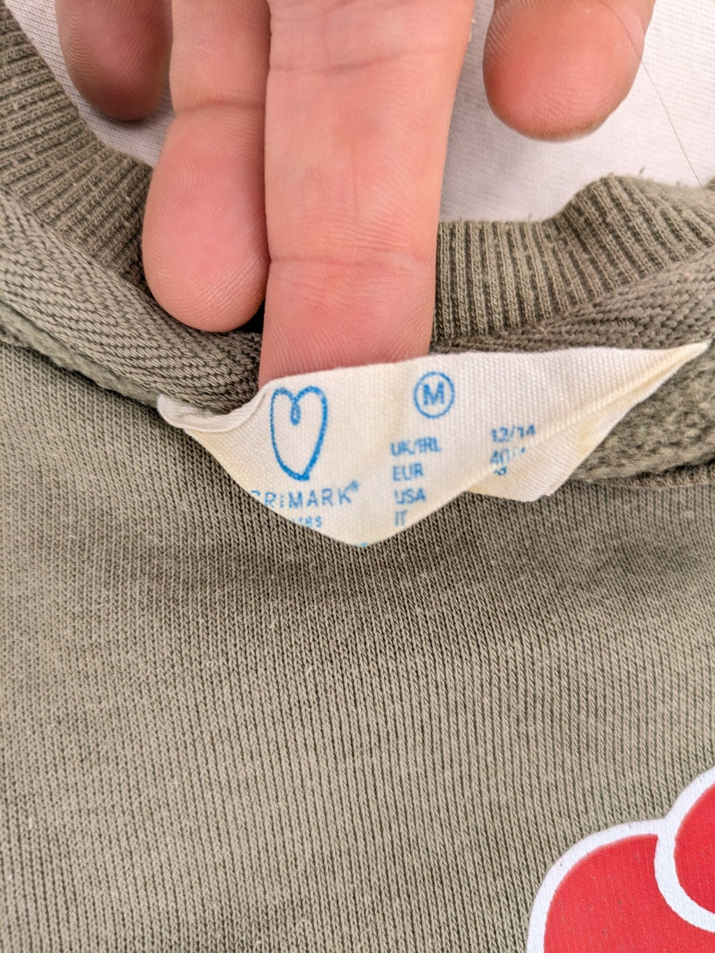 Naruto khaki turtle neck jumper featuring red Akatsuki cloud and Sharingan symbols.