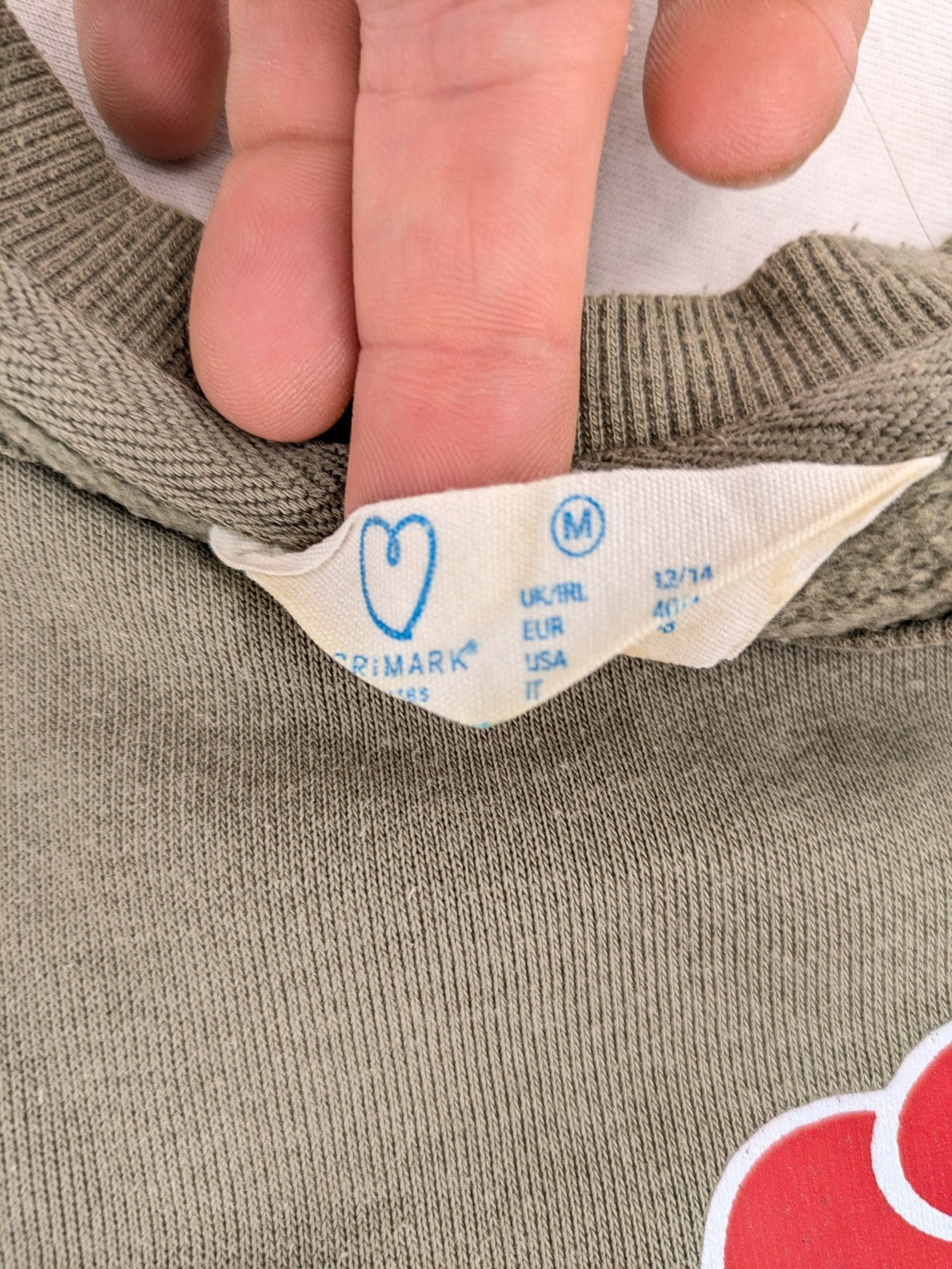 Naruto khaki turtle neck jumper featuring red Akatsuki cloud and Sharingan symbols.