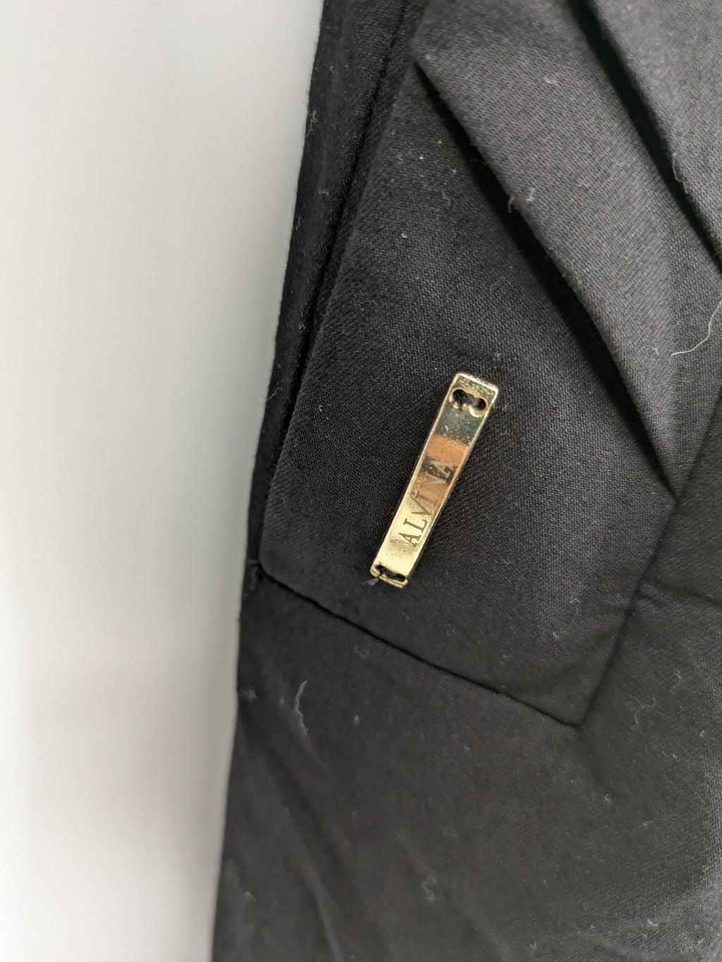 Alvina black trench coat with lace collar and gold buttons, belted waist design.