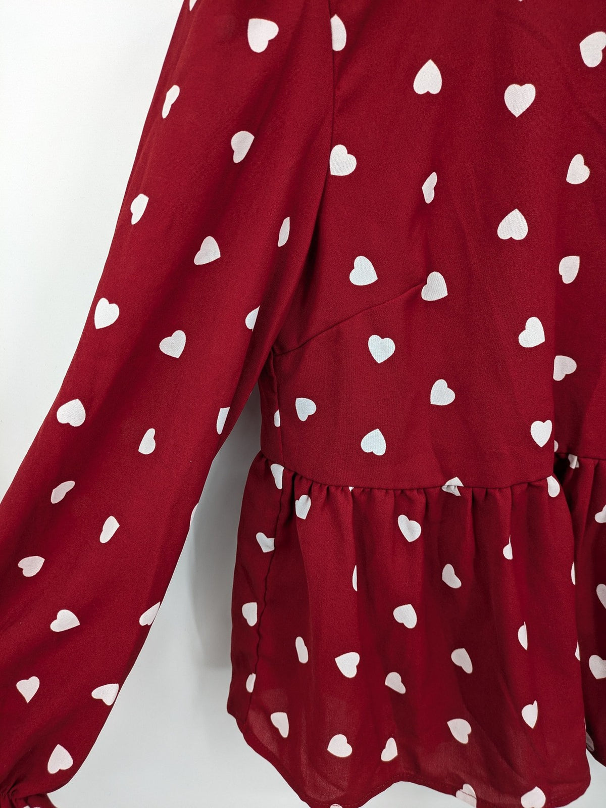 SHEIN burgundy top with white heart pattern and ruffled neckline detail.