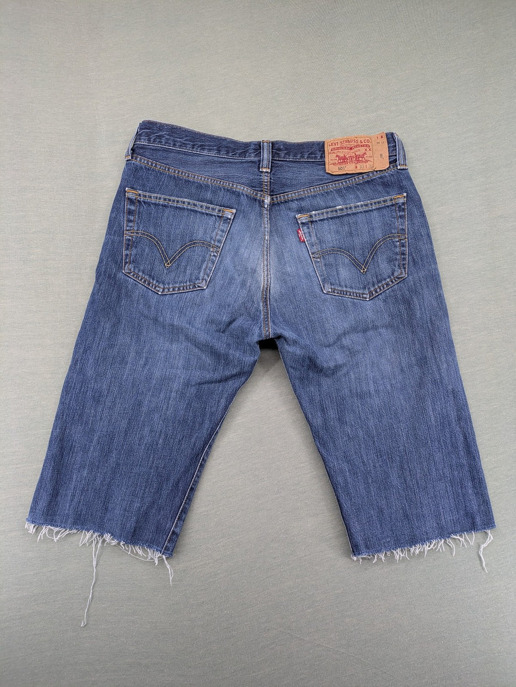 Levi's blue cut-off shorts with frayed hem, classic 5-pocket design, button fly.