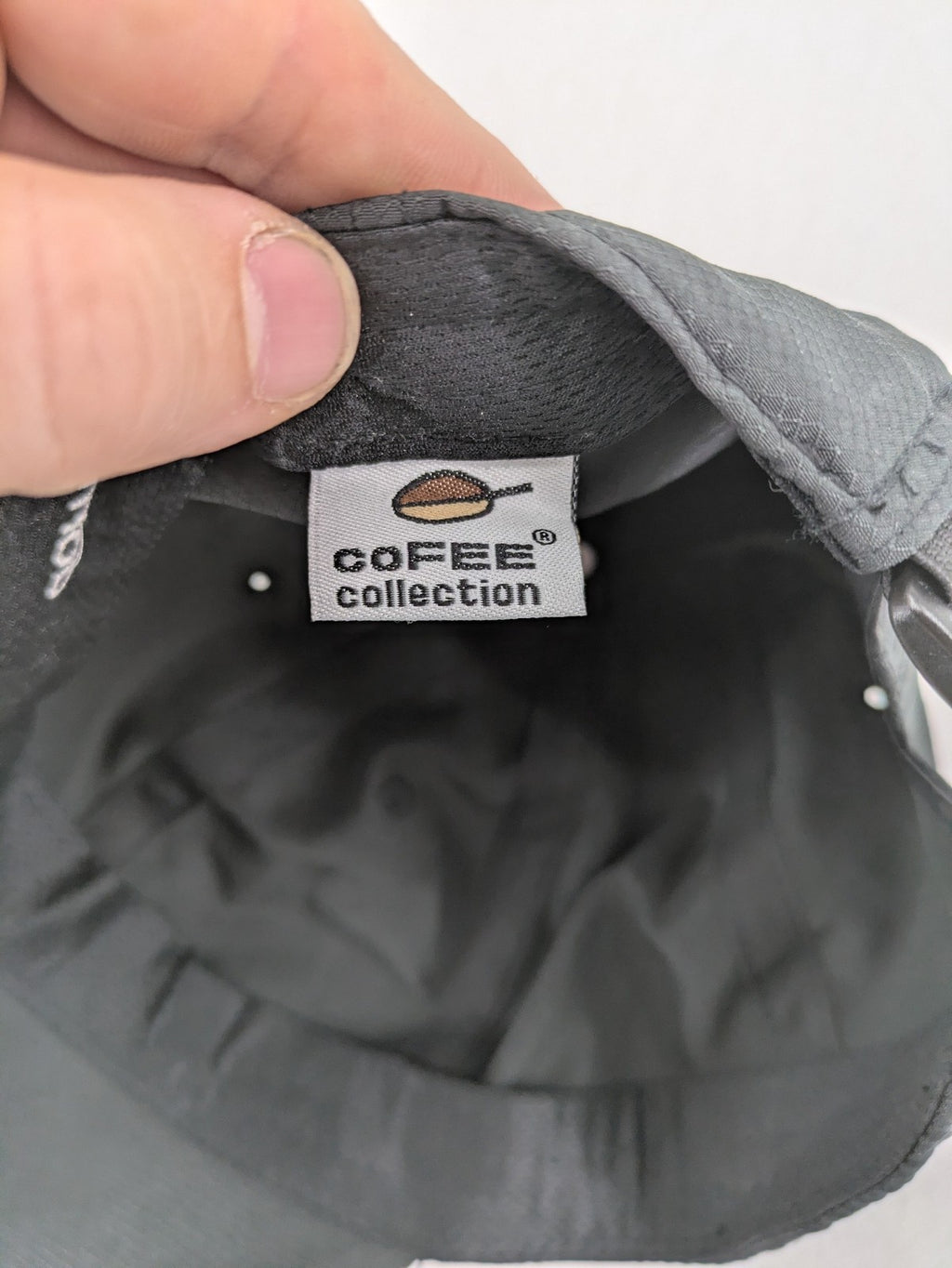 Funktional grey baseball cap with embroidered Dormakaba logo and modern ripstop texture.