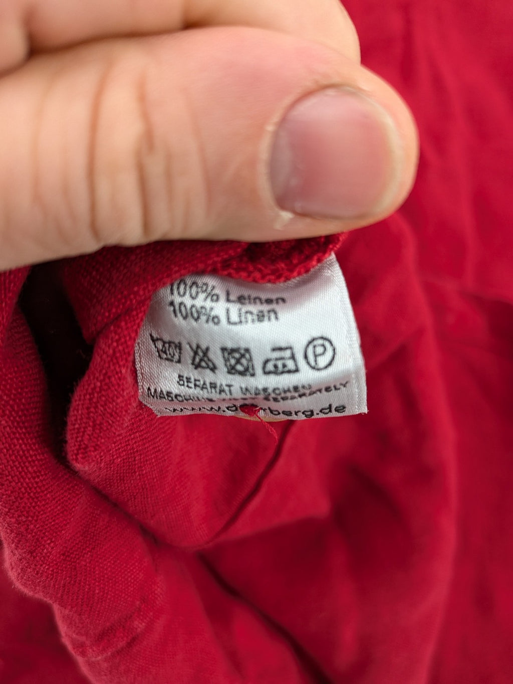 Deerberg red short-sleeve linen blouse with collar, button placket, and side slits.