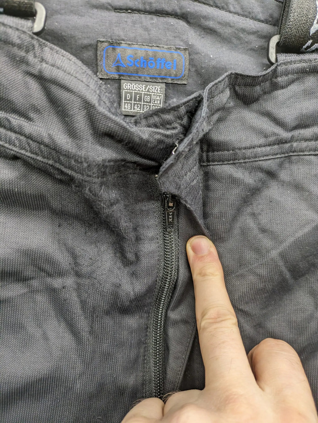 Schoffel black ski pants with adjustable straps, zip pockets, and snow gaiters.