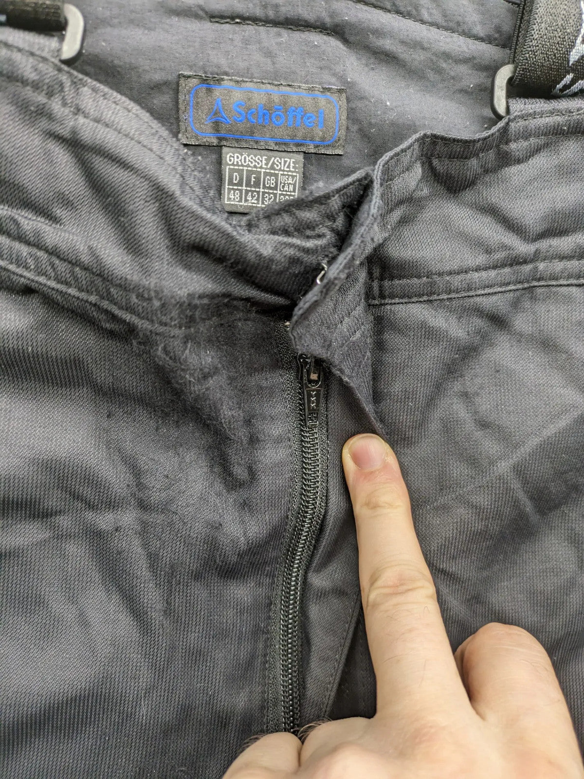 Schoffel black ski pants with adjustable straps, zip pockets, and snow gaiters.