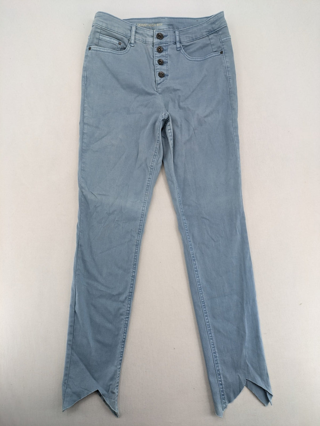Yessica blue skinny jeans high rise with button fly and V-cut hem detail.