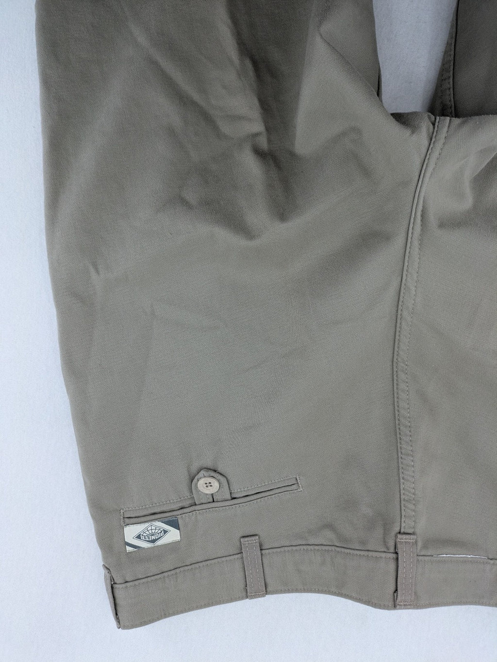 Pioneer beige chino trousers with pleats, straight leg, and buttoned back pocket.
