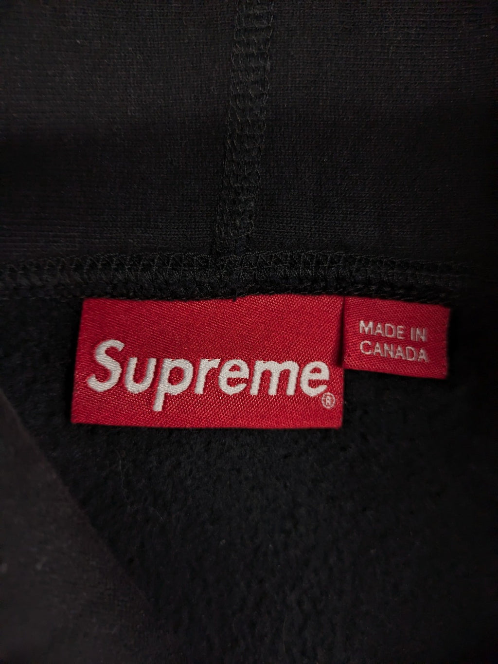 Supreme grey hoodie with embroidered small box logo, kangaroo pocket, and ribbed cuffs.