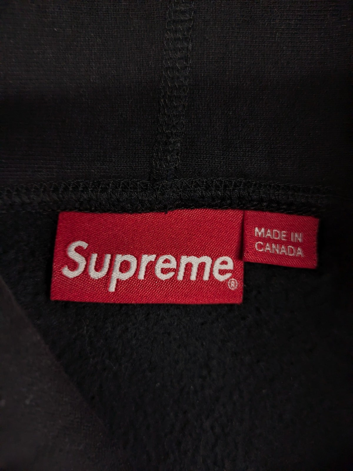 Supreme grey hoodie with embroidered small box logo, kangaroo pocket, and ribbed cuffs.