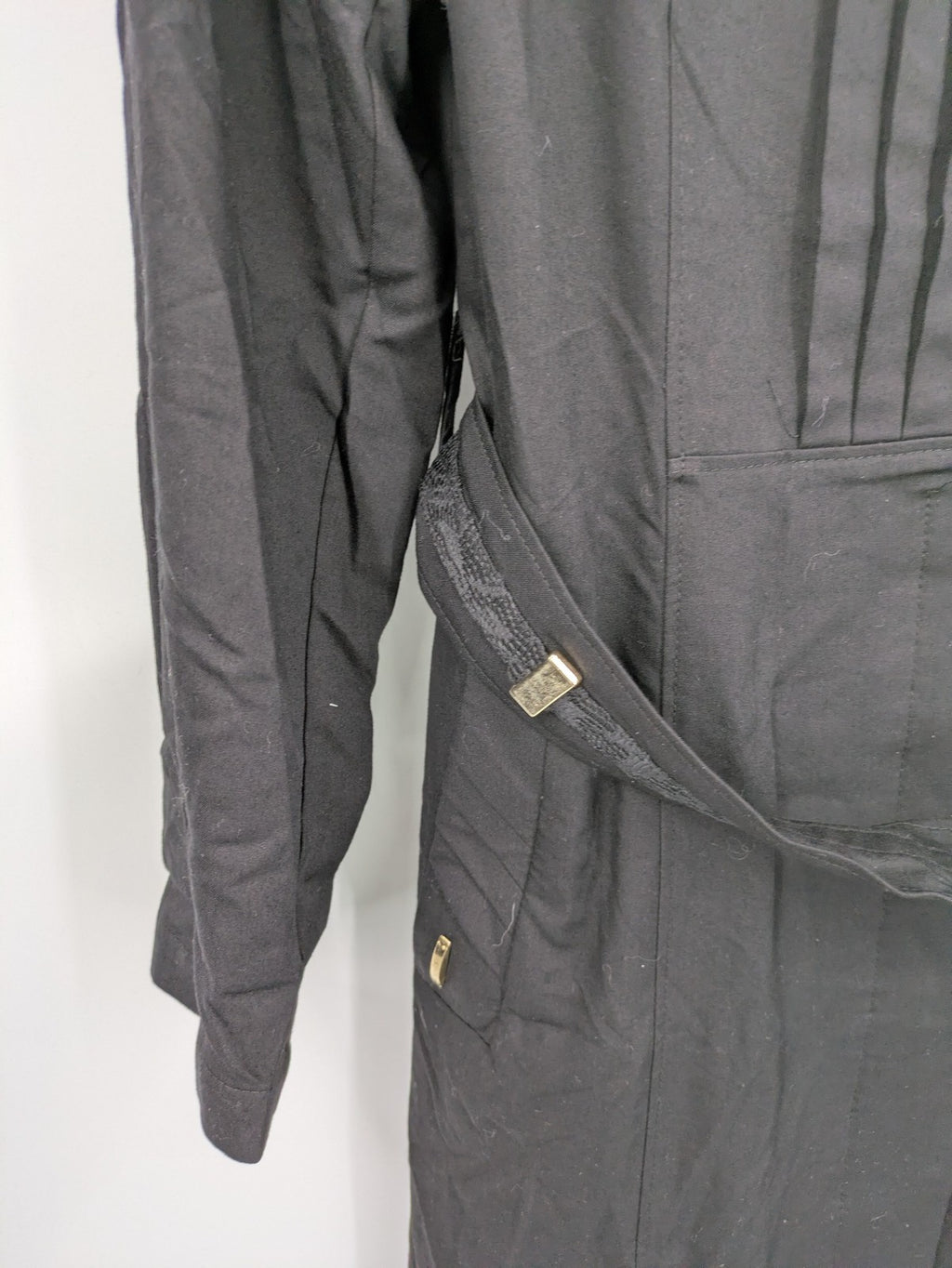 Alvina black trench coat with lace collar and gold buttons, belted waist design.