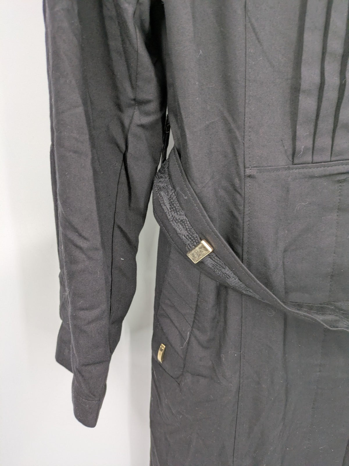 Alvina black trench coat with lace collar and gold buttons, belted waist design.