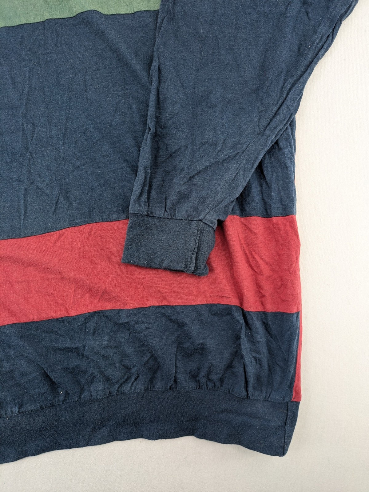 C&A green navy red colorblock long sleeve top with wide striped pattern and round neckline.