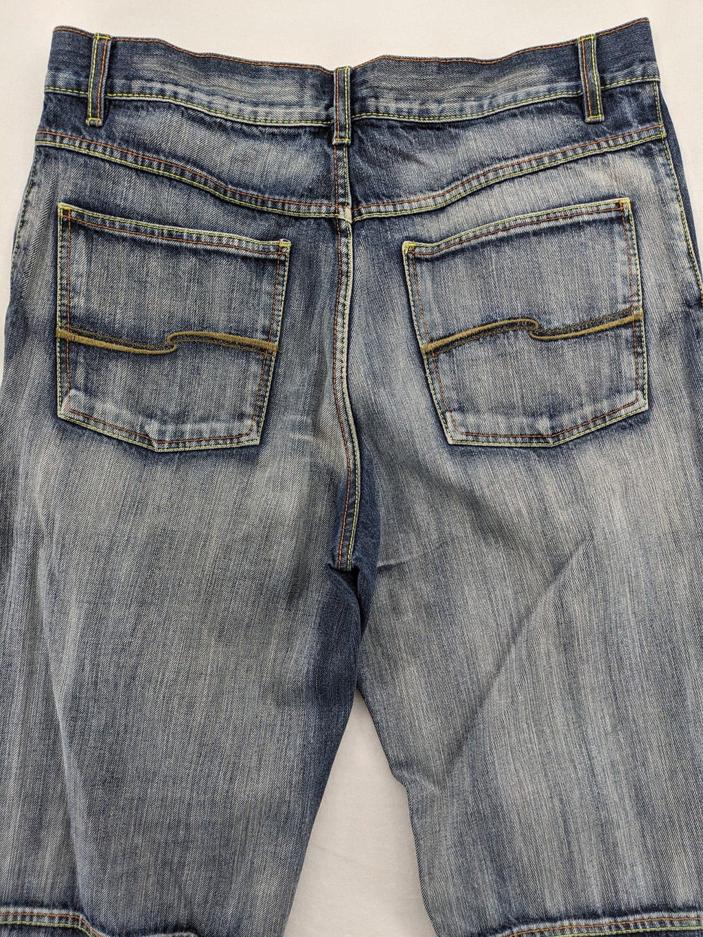 Identic orange straight jeans with paneled design and contrasting yellow stitching.