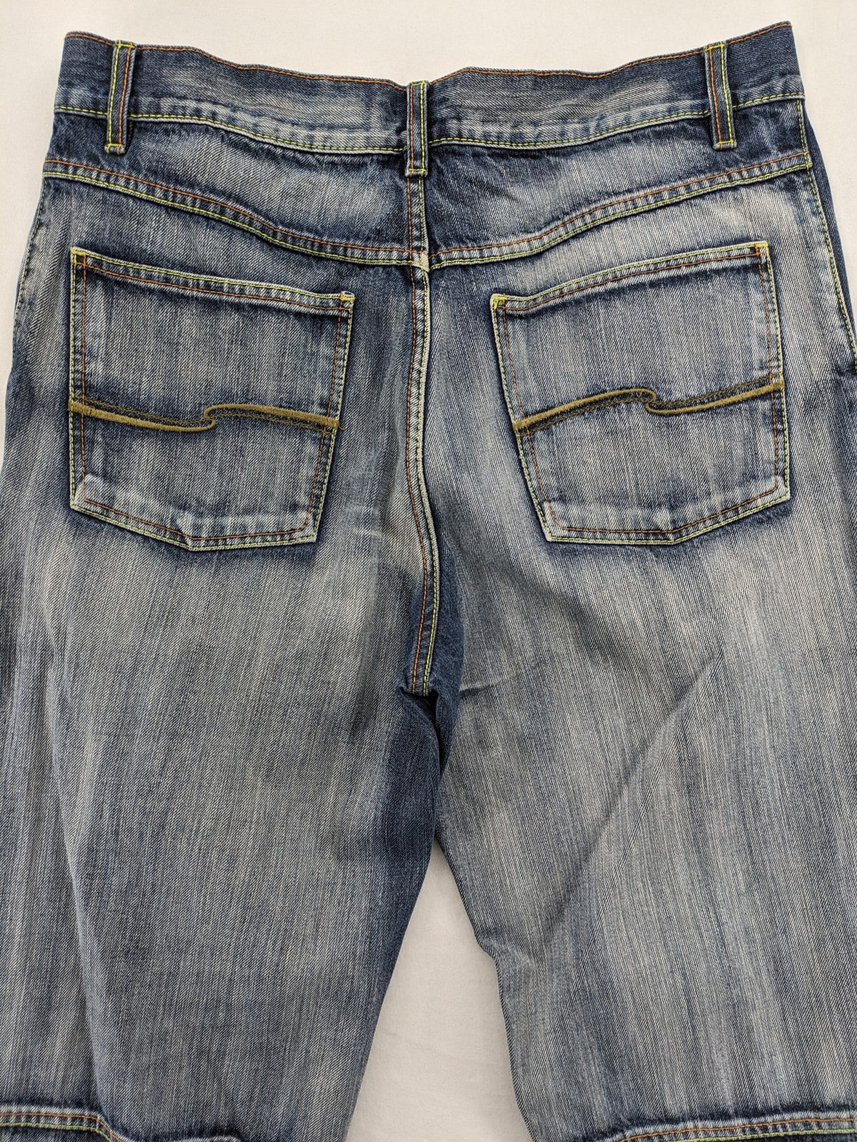 Identic orange straight jeans with paneled design and contrasting yellow stitching.