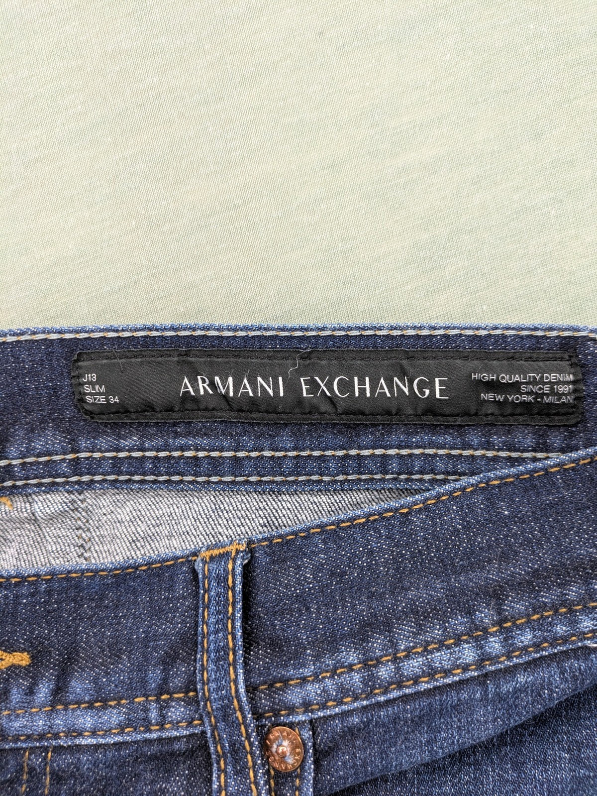 Armani Exchange blue slim fit jeans with distressed details and classic 5-pocket design.