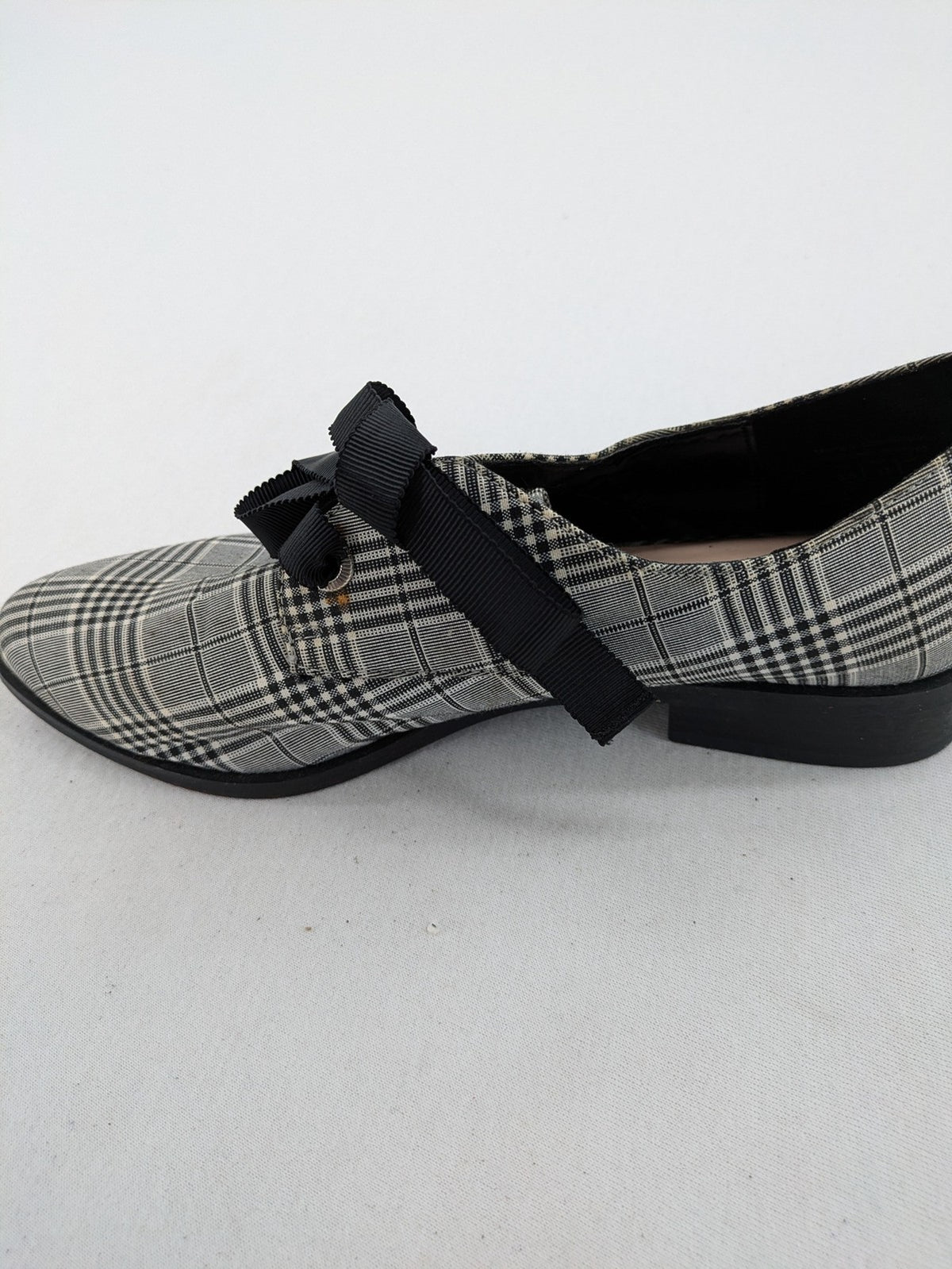 ALDO black and white checkered loafers with decorative bow detail and pointed toe.