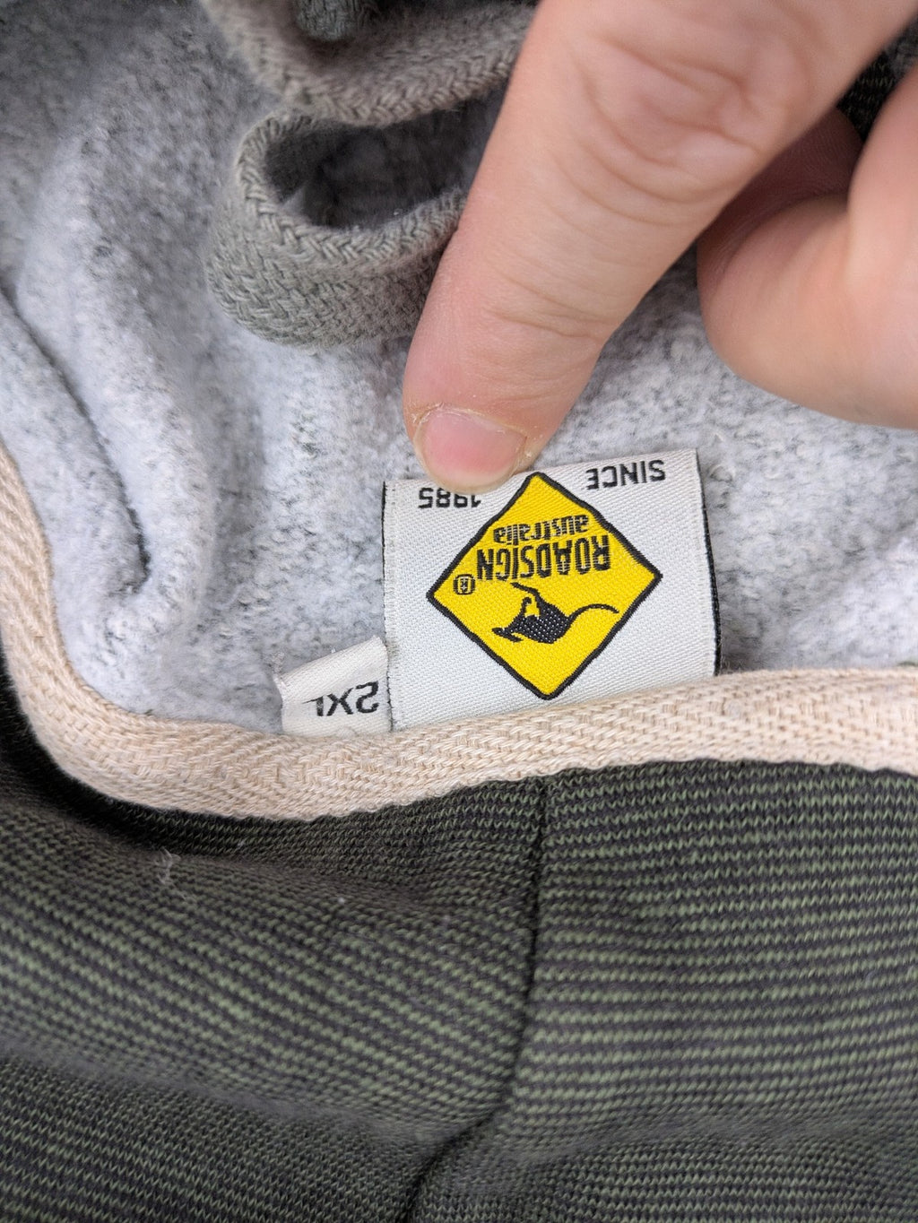 Roadsign Australia green hoodie with mountain graphic print and logo patch on sleeve.